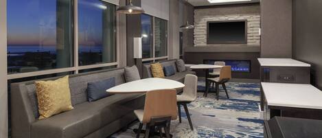 A modern lounge area with a sofa, chairs, a table, and a fireplace.