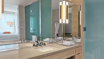 Une salle de bain moderne dotée d’un grand miroir, de deux vasques et d’une cabine de douche en verre.