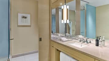 A modern bathroom with a large mirror, two sinks, and a towel rack.