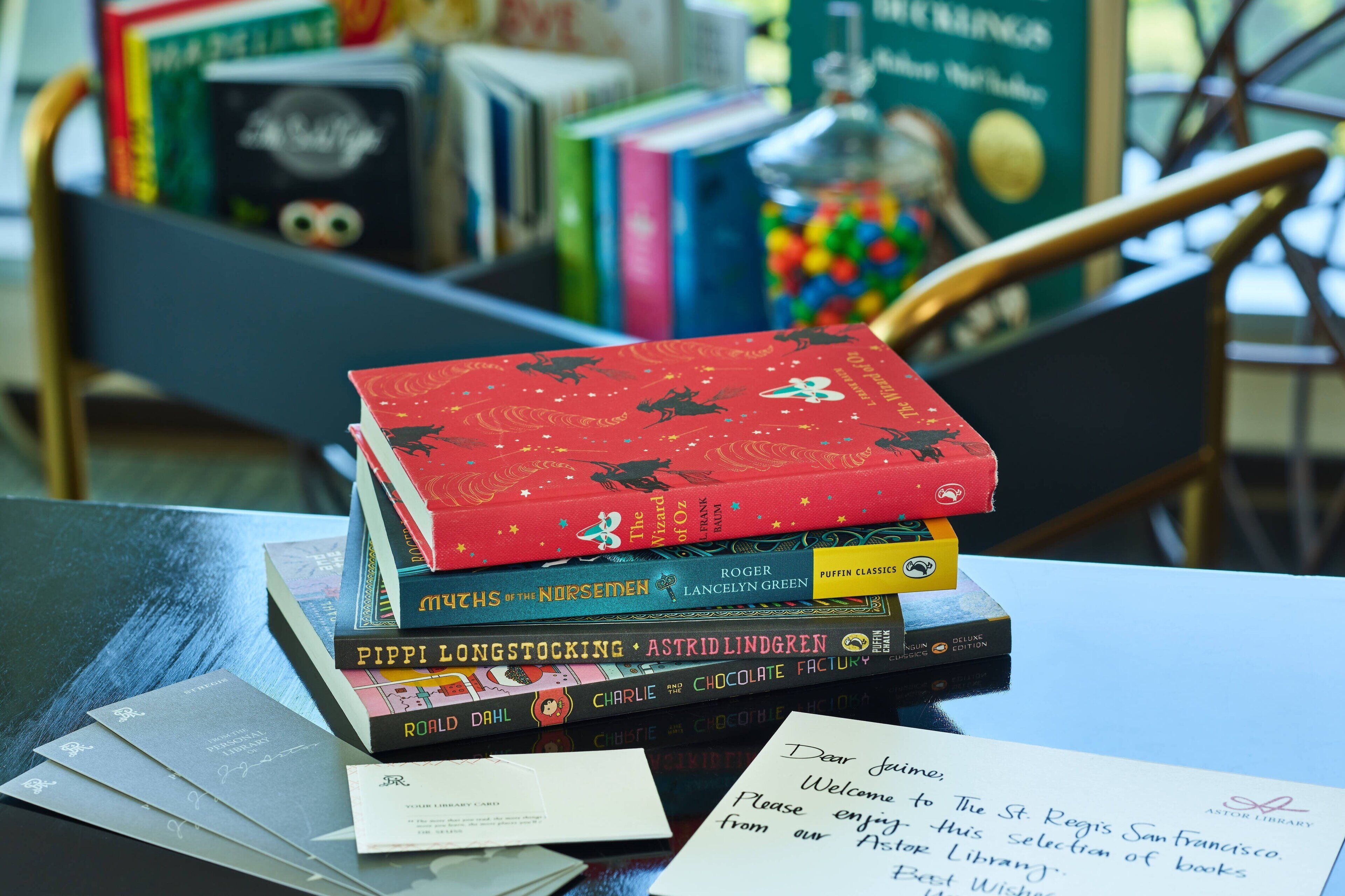 A stack of books on a table with a letter and a card.
