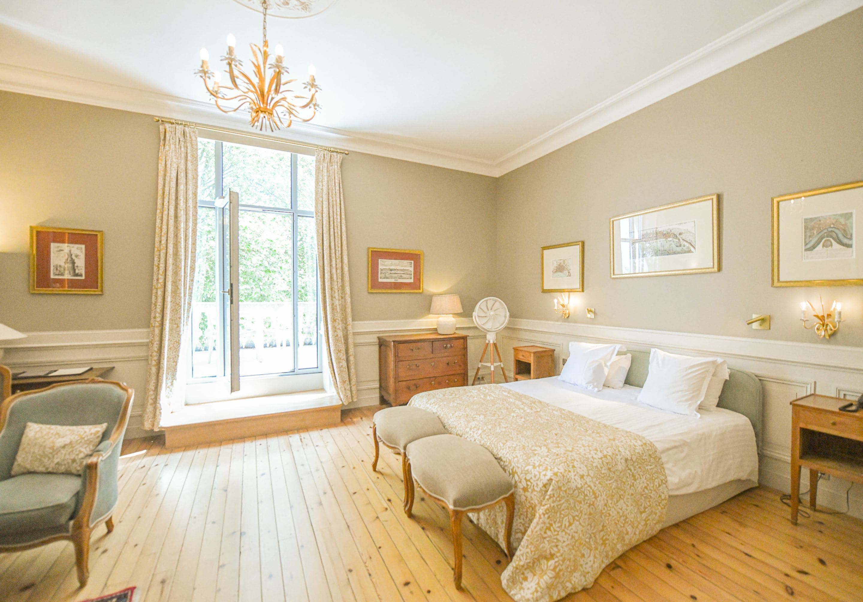 A bedroom with a large bed, a dresser, a chair, and a window with curtains.