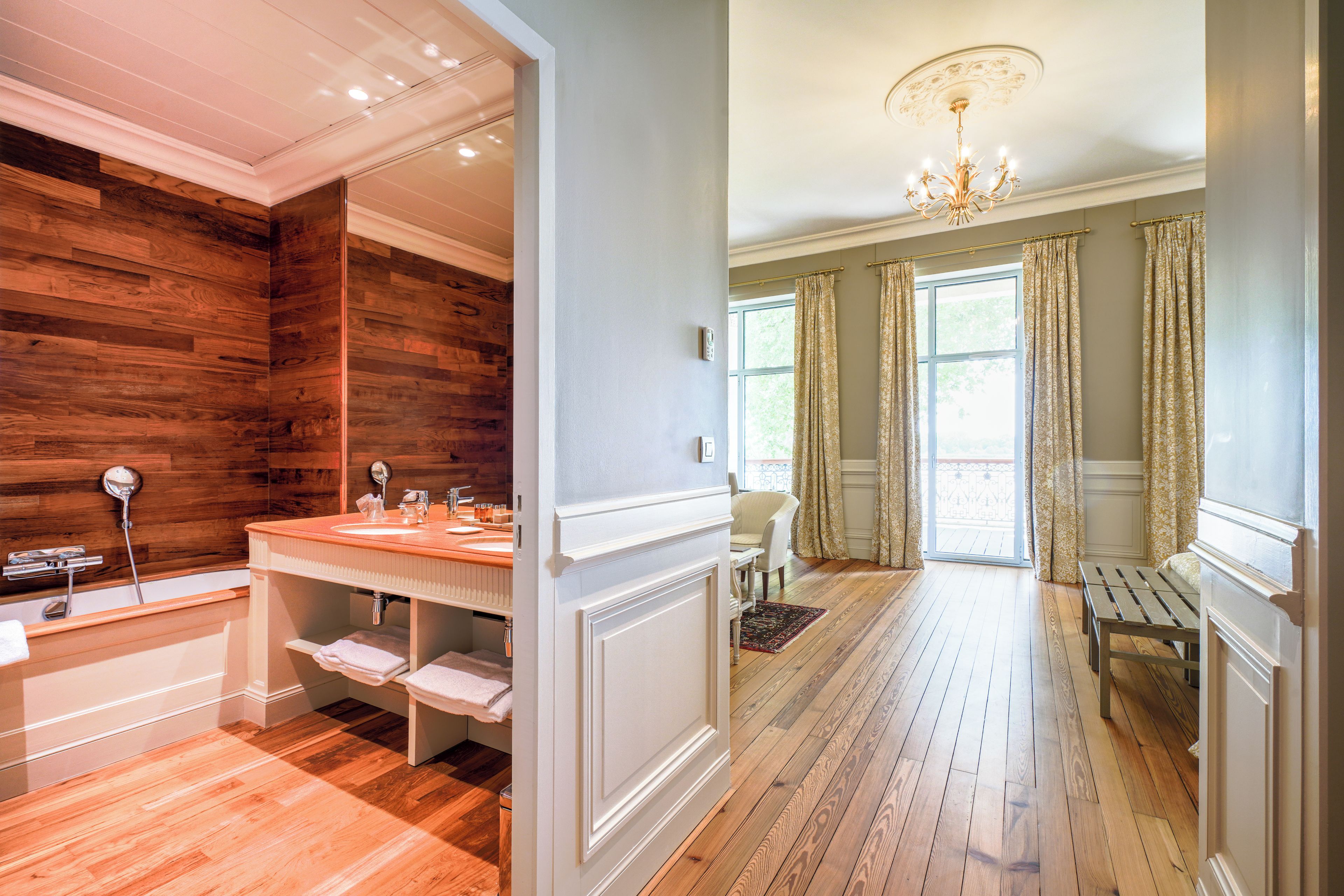 Baño con pared de madera, lavamanos y ducha.