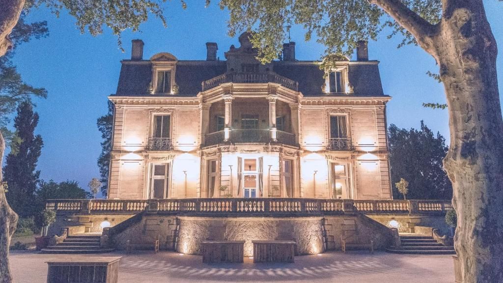 Un edificio grande y histórico con una entrada imponente, múltiples ventanas y una fachada simétrica.