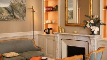 A living room with a fireplace, a sofa, a coffee table, and a bookshelf.