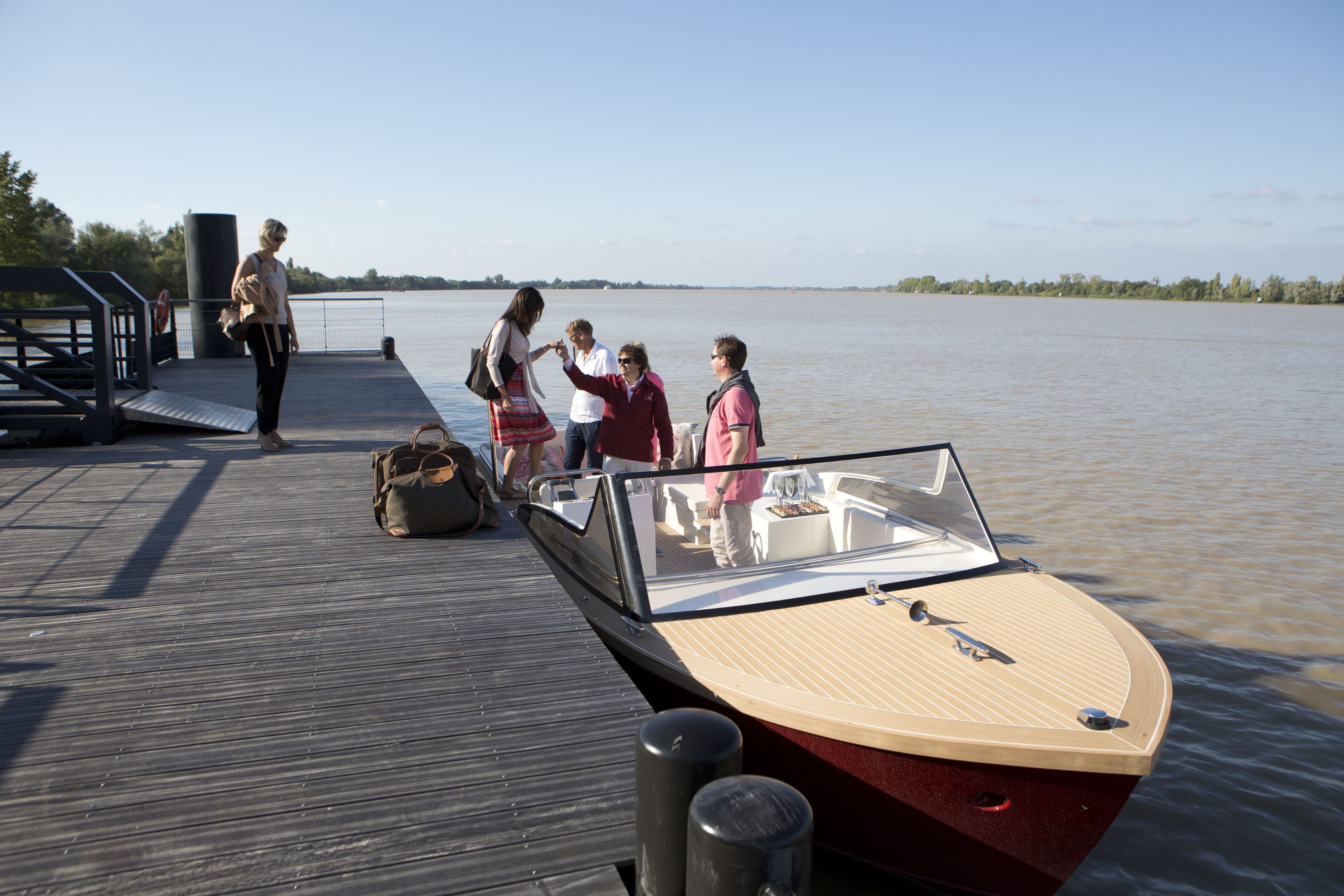 A wooden boat docked at a pier with a clear view of the water.