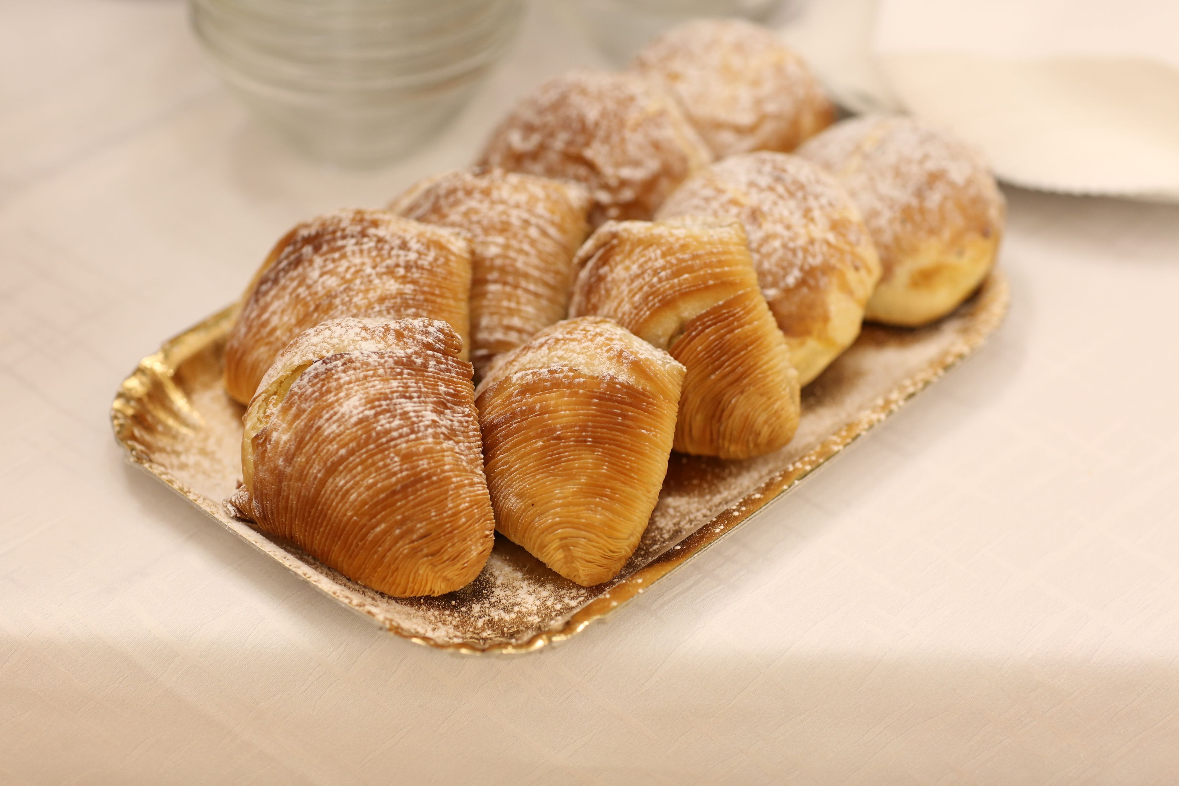 A tray of pastries dusted with powdered sugar.