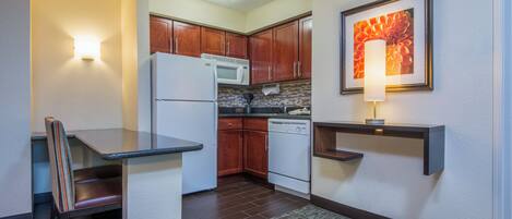 A compact kitchen with a refrigerator, microwave, and dishwasher.