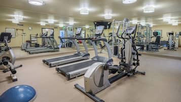 A gym with treadmills, elliptical machines, and free weights.