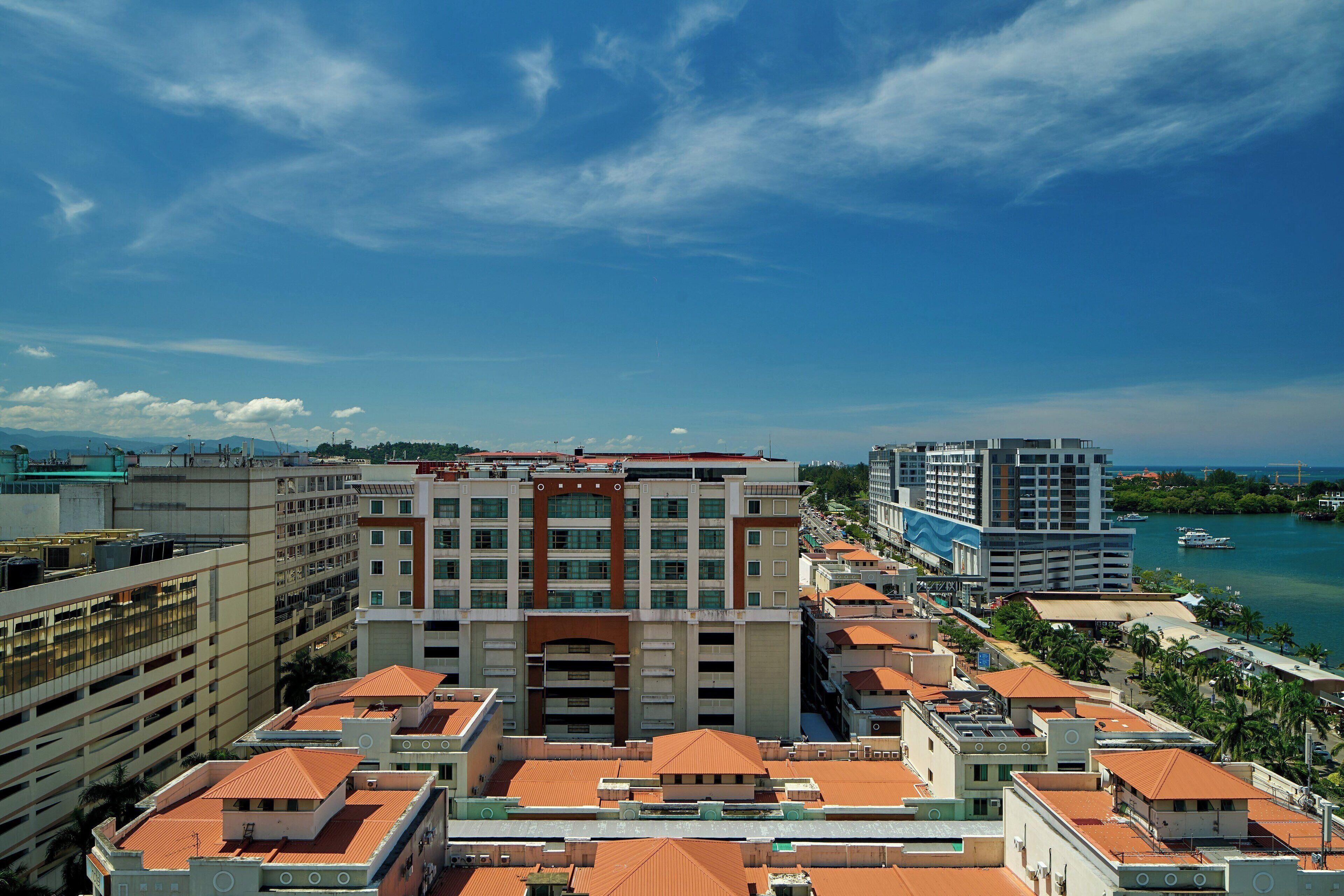 A high-rise hotel with multiple floors, a central atrium, and a view of the sea.