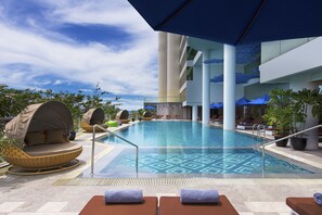 A pool area with lounge chairs, a hot tub, and umbrellas. - Le Meridien Kota Kinabalu (Kota Kinabalu)