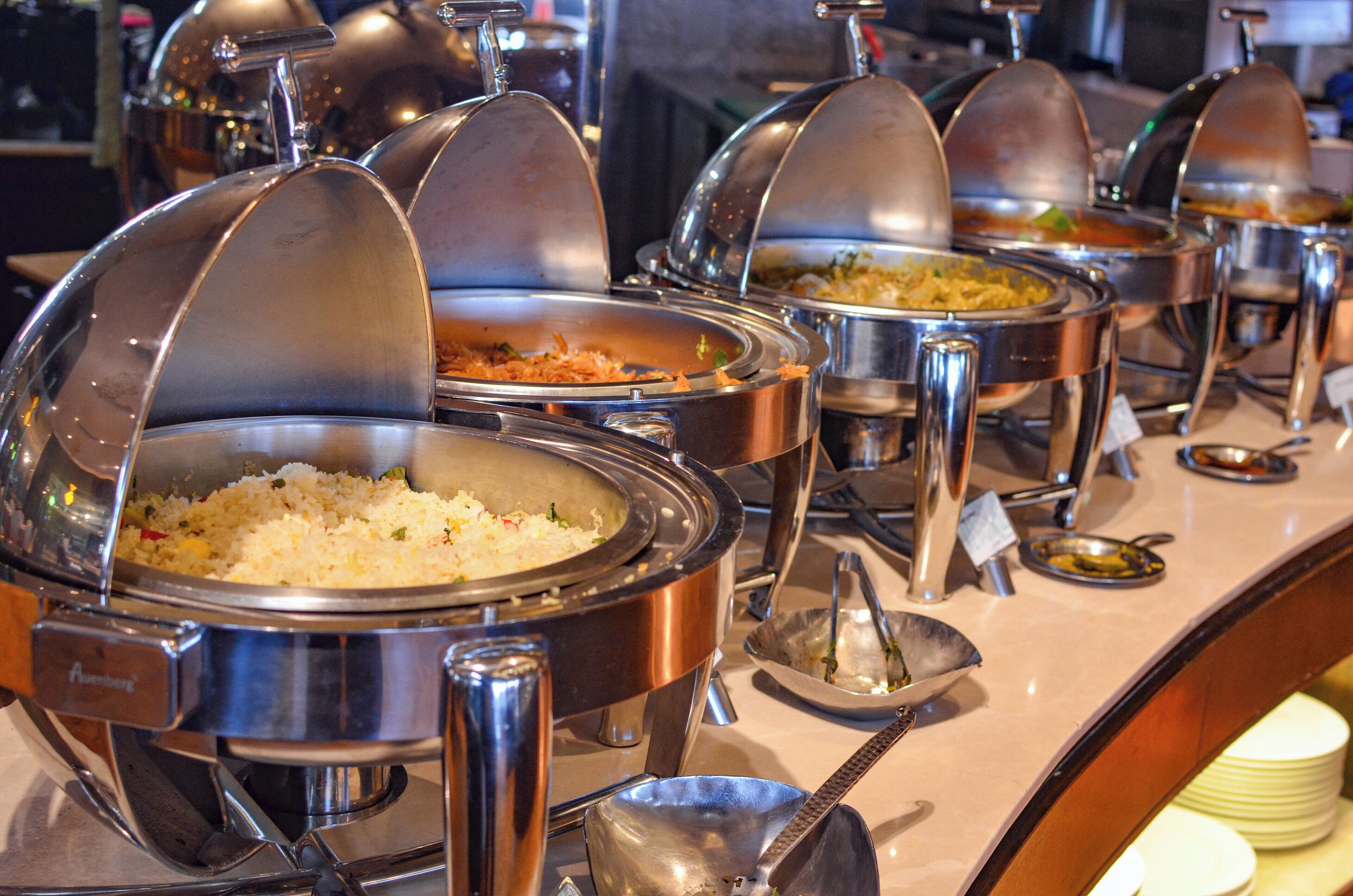 Een buffetopstelling met verschillende overdekte stations voor eten.