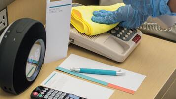 A desk with a remote control, a calculator, a yellow cloth, a pen, and a sign that reads "MAKE THE CONNECTION".