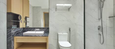 Een moderne badkamer met een marmeren wastafel, een houten opbergmeubel en een douche met glazen wanden.