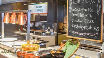 A buffet counter with a chalkboard menu listing an omelette option.