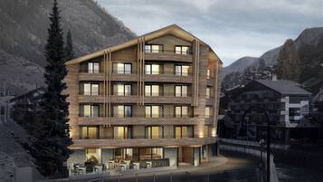 A multi-story hotel with a wooden facade, balconies, and a riverside terrace.
