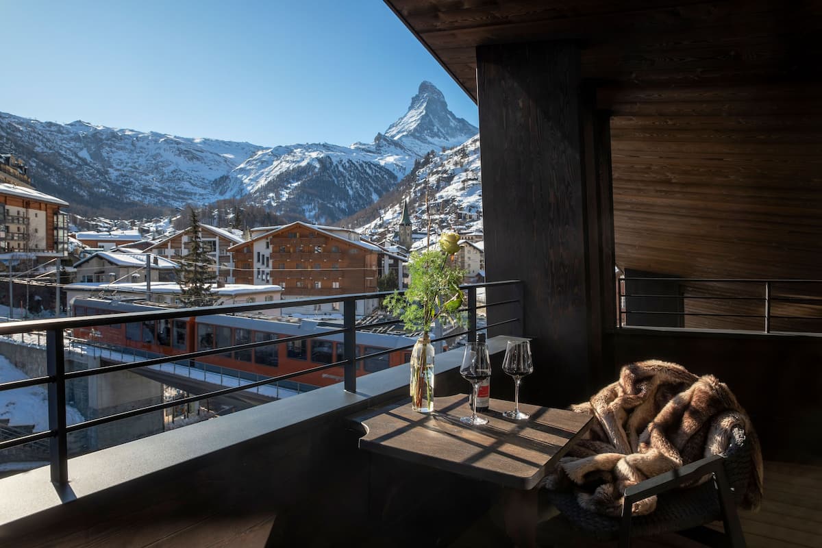 A balcony with a view of a mountain and a train.