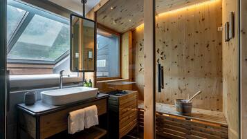 A modern bathroom with a skylight, wooden walls, a sink, and a sauna area.