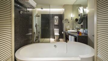 A modern bathroom with a freestanding bathtub, a glass-enclosed shower, and a vanity with a sink and mirror.