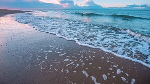 A beach with waves gently lapping onto the shore. - Sheraton Haikou Hotel (Haikou)