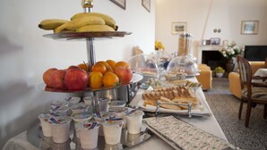 A buffet with fruits, yogurt, and sandwiches.