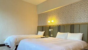 Une chambre d’hôtel avec deux lits, une tête de lit à motifs et un luminaire fixé au mur.