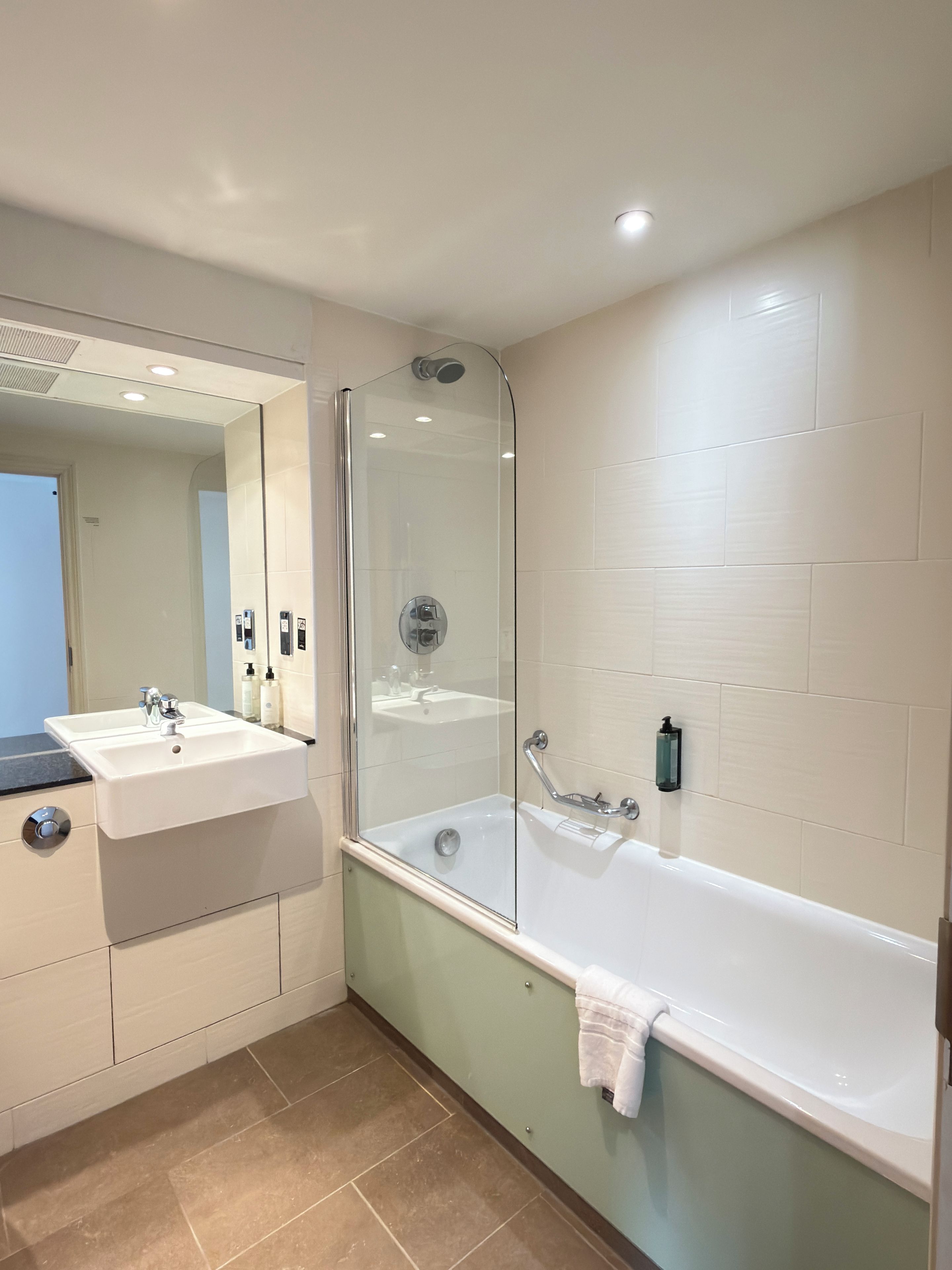 A modern bathroom with a glass-enclosed shower, a white sink, and a bathtub.