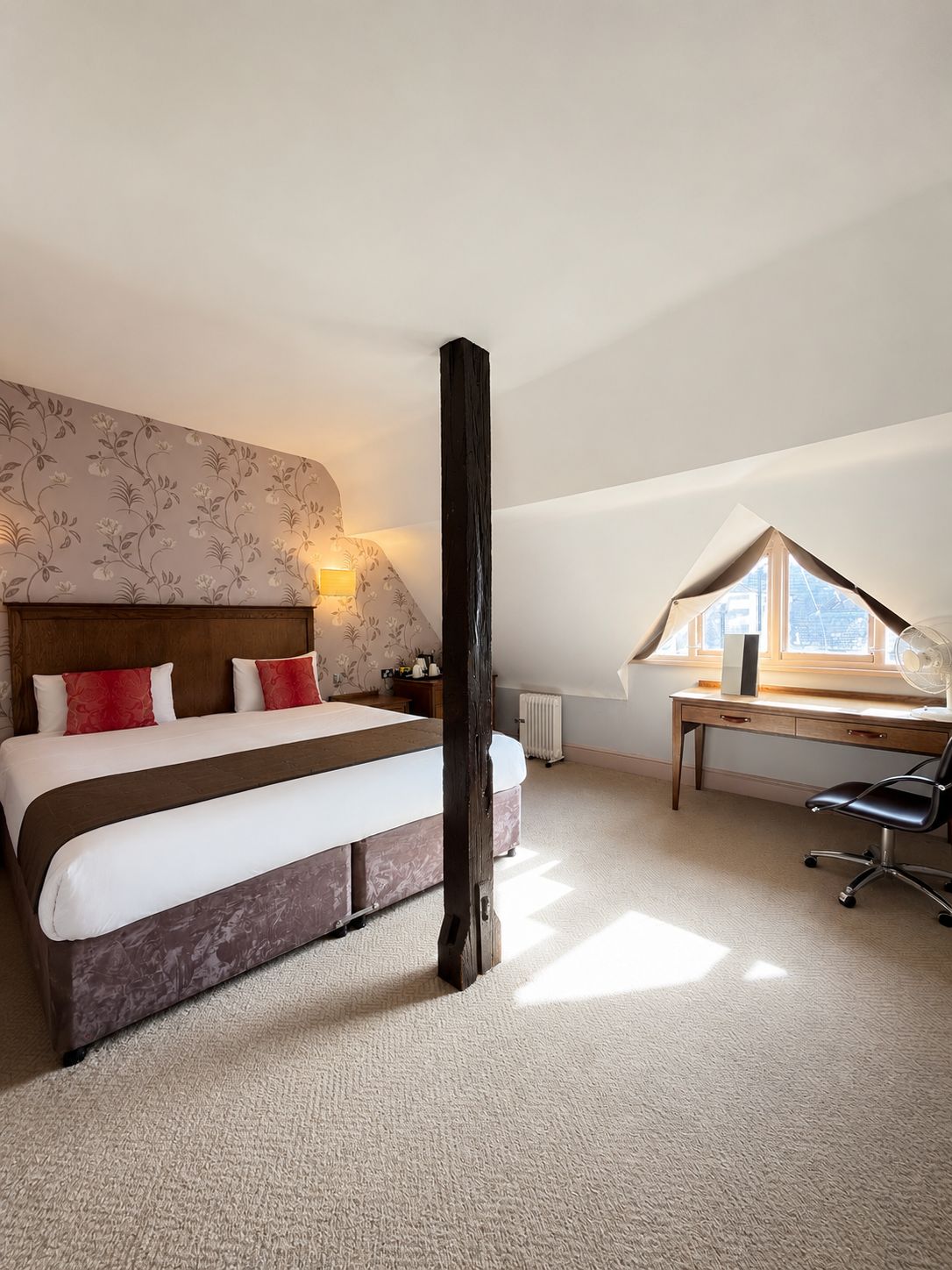 Ein Schlafzimmer mit einem großen Bett, einem Schreibtisch und einer Heizung.