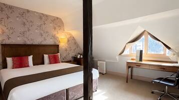 A bedroom with a large bed, a desk, and a radiator.