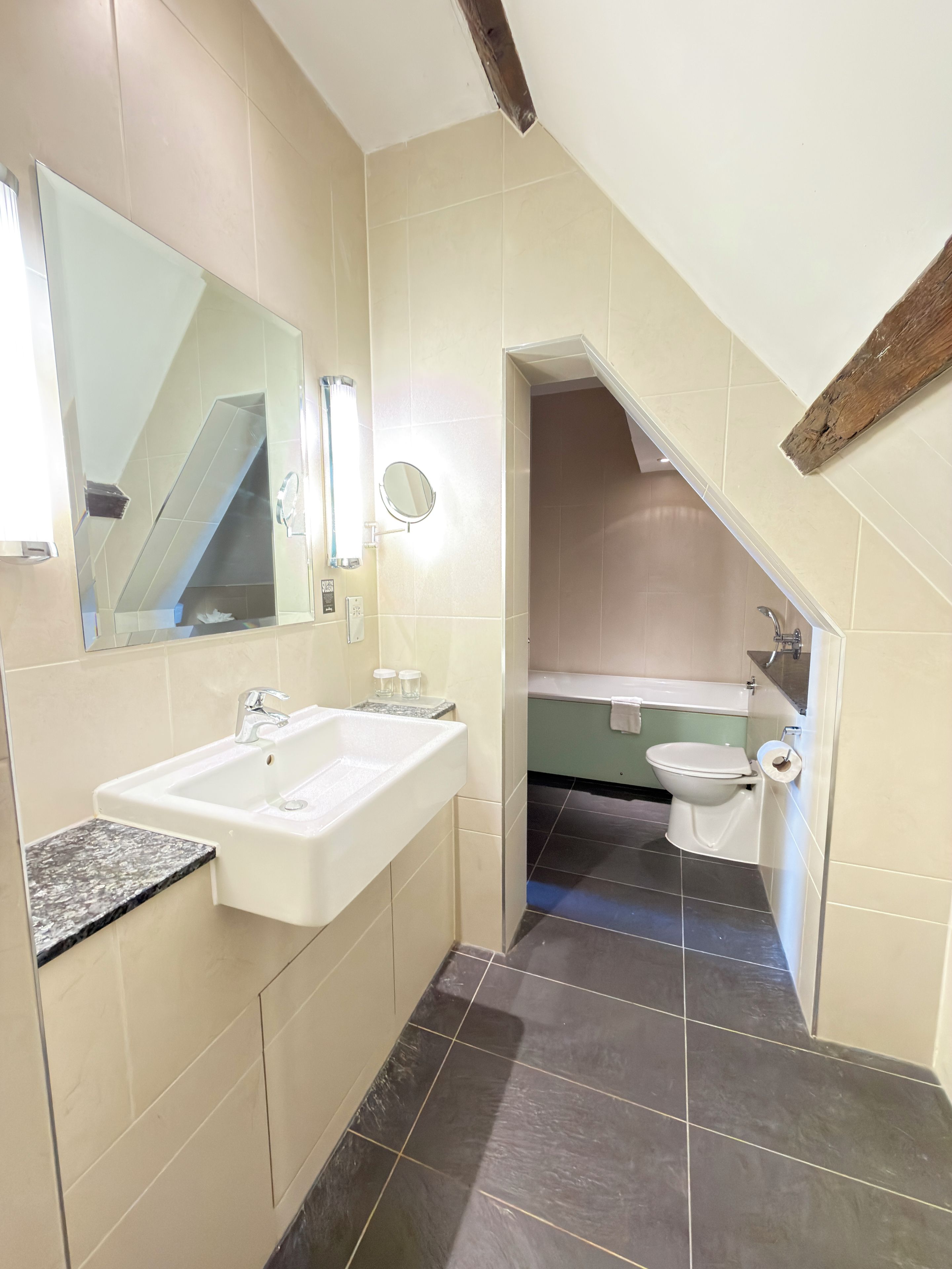 A bathroom with a sink, mirror, and toilet.