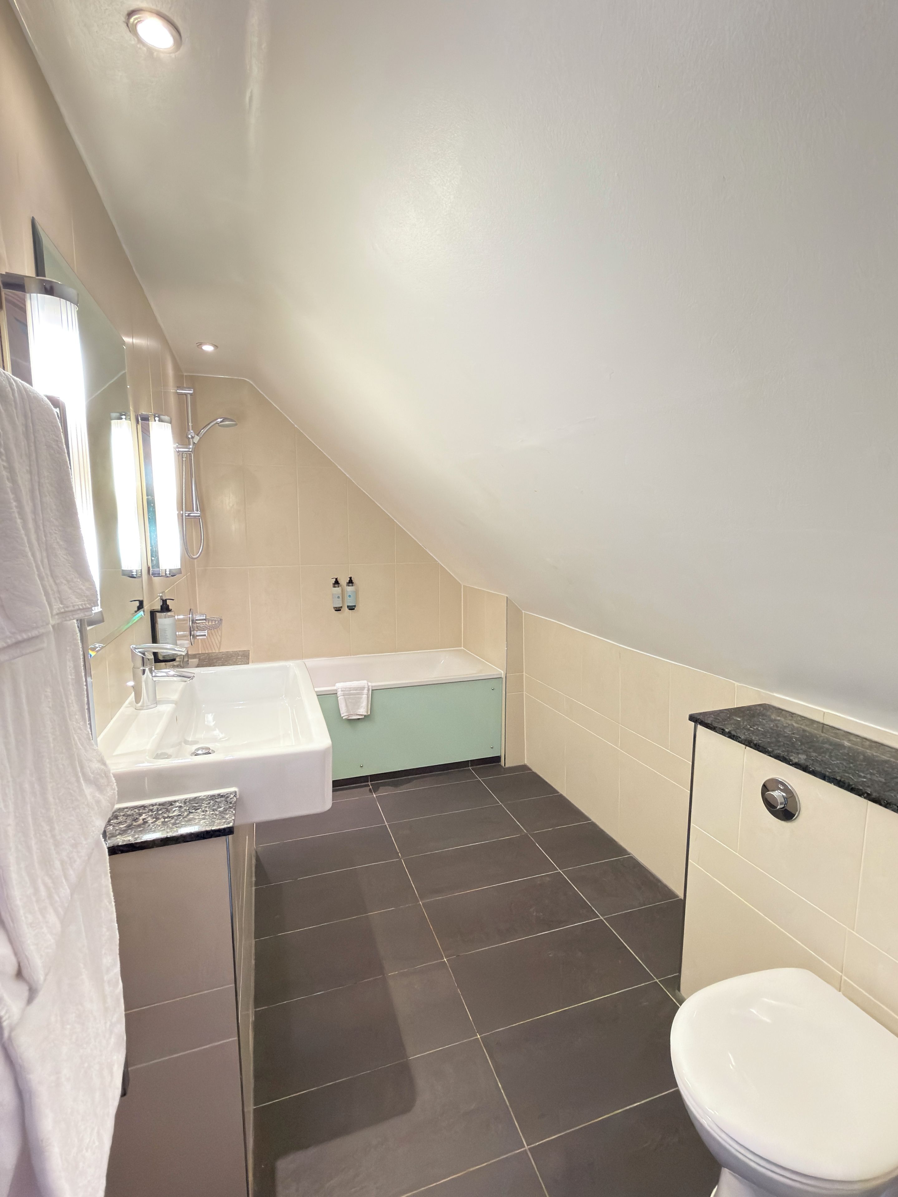 A modern bathroom with a sink, bathtub, and toilet.