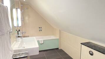 A modern bathroom with a sink, bathtub, and toilet.