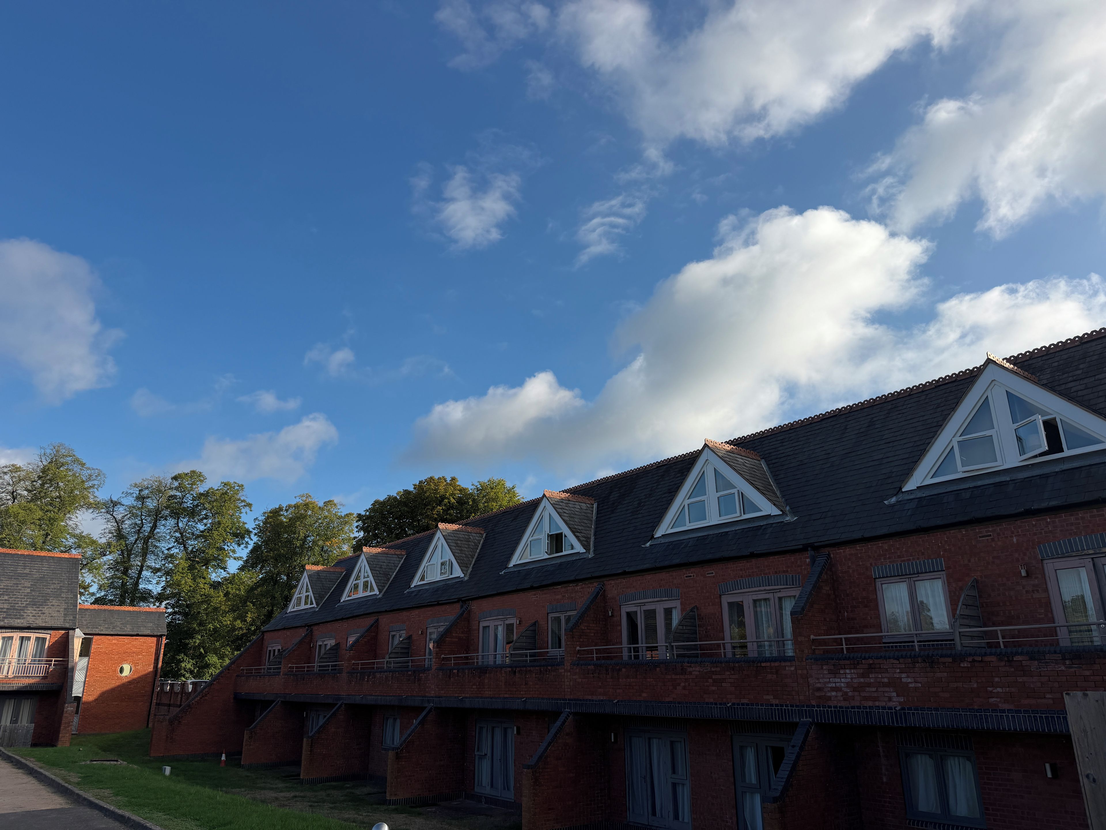 A row of brick buildings with pitched roofs and dormer windows.