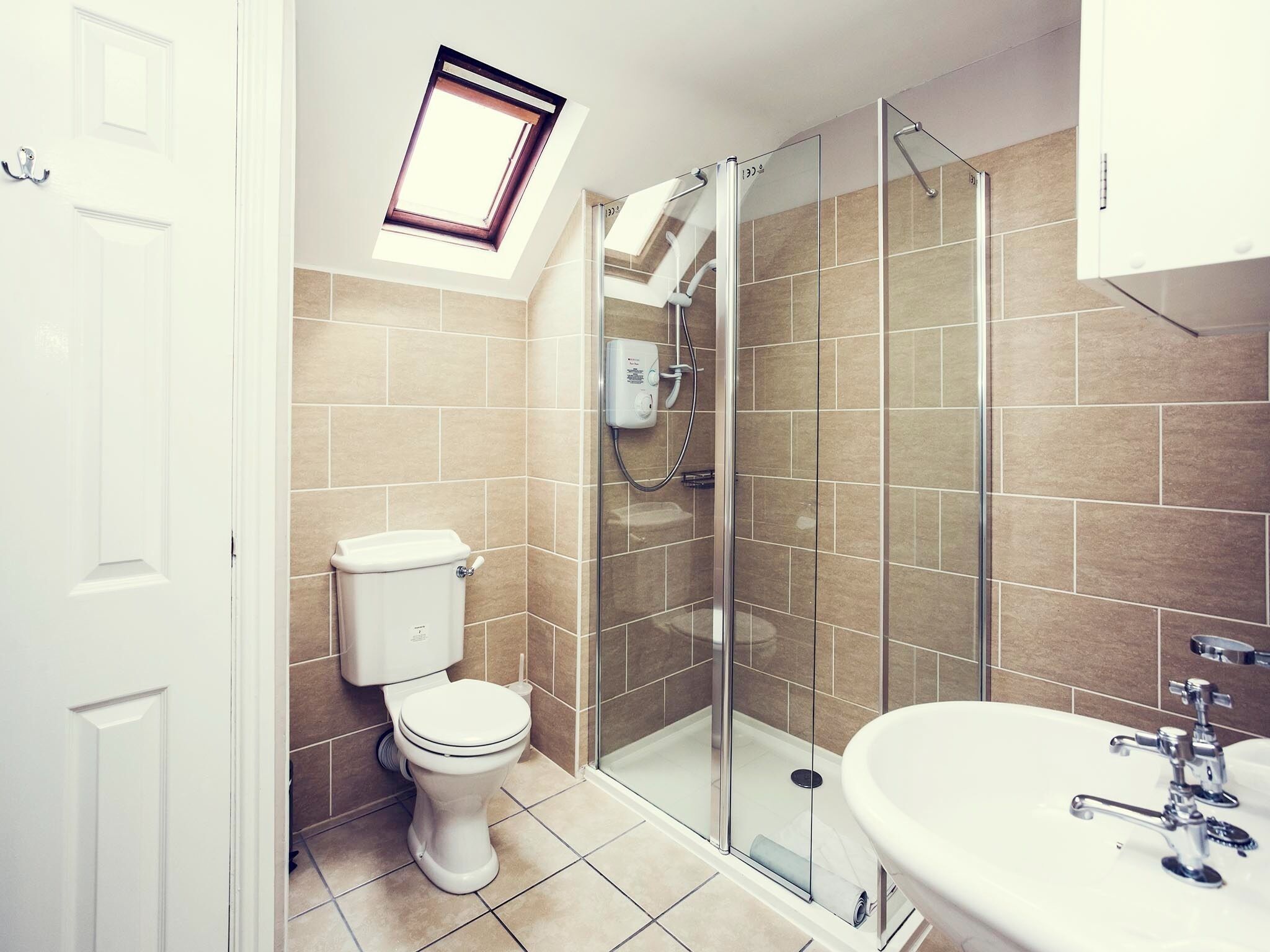 A modern bathroom with a toilet, shower, and sink.