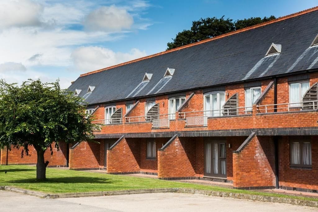 Un bâtiment en briques doté de nombreuses fenêtres et de balcons, qui ressemble probablement à un hôtel ou à une auberge de jeunesse.
