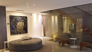 Een modern interieur met een ronde zithoek, een glazen scheidingswand en een minimalistisch ontwerp.