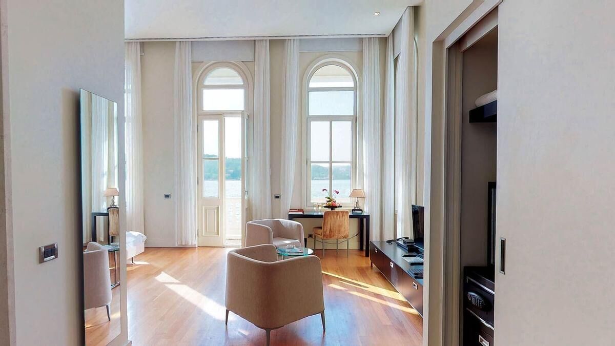 A spacious living room with a large window, a dining area, and a TV.