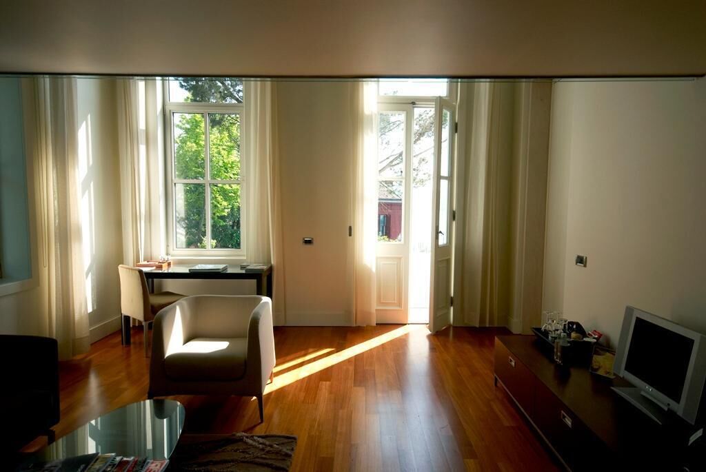 A spacious living room with a large window, a dining area, and a television.