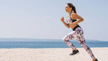 Guests can enjoy a serene beachside run with breathtaking views of the ocean and distant landforms.