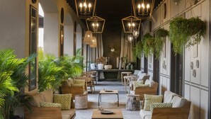 Un rincón acogedor con mobiliario de madera, plantas colgantes e iluminación decorativa.