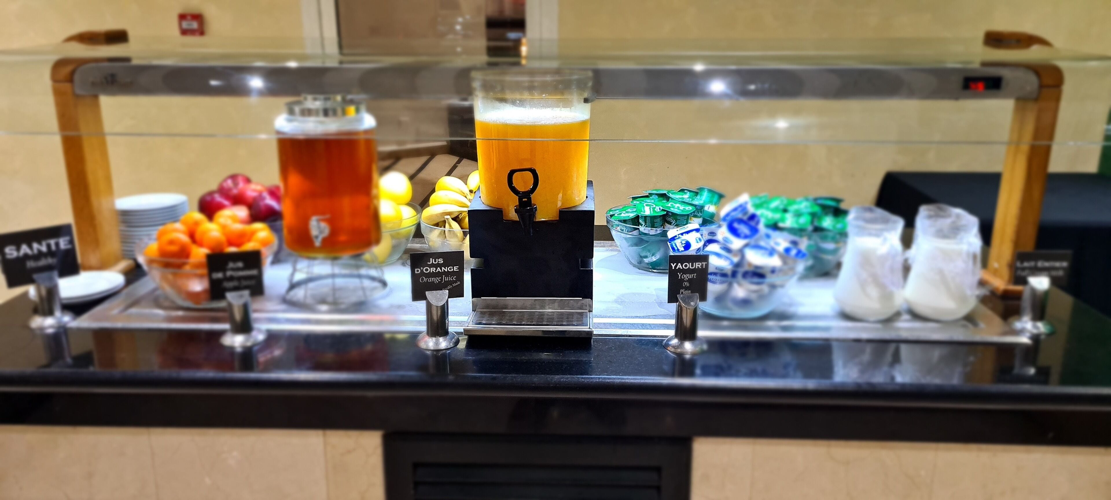 A beverage station with various drinks and a coffee machine.