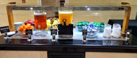 A beverage station with various drinks and a coffee machine.