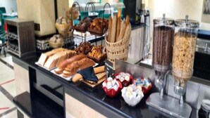 A buffet counter with various food items including bread, pastries, and a beverage dispenser. - Hotel Borj Rabat – A member of Barcelo Hotel Group (Rabat)