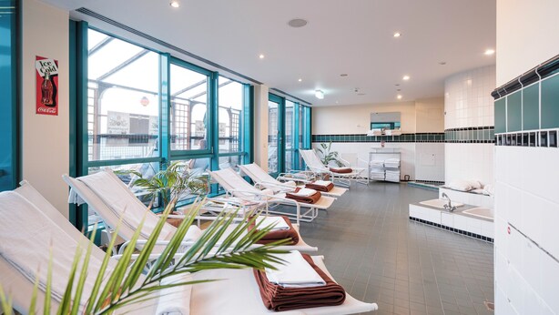 A modern spa with sun loungers, a large window, and a sink area. - Mercure Hotel Frankfurt Airport Langen (Langen)