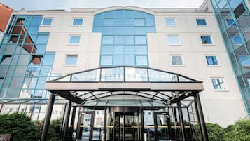 The entrance of the Mercure Hotel with a glass canopy and a modern design.