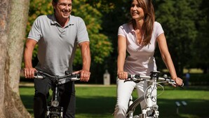A man and a woman riding bicycles in a park. - Mercure Hotel Frankfurt Airport Langen (Langen)