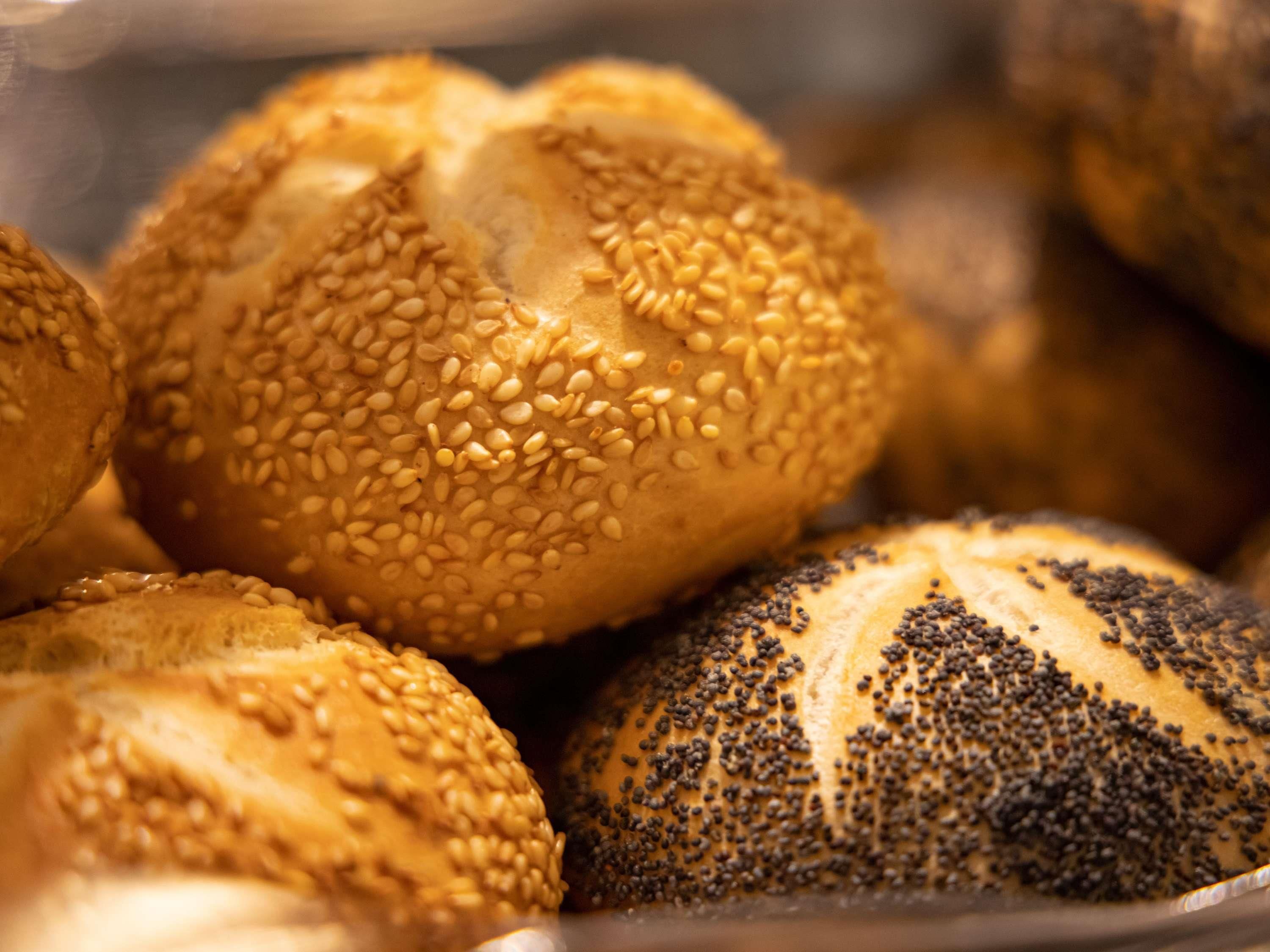 A close-up of various breads with sesame and poppy seeds.