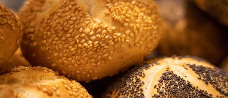 A close-up of various breads with sesame and poppy seeds.