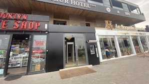The exterior of the AZUR HOTEL with a sign for Brooklyn Smoke shop and La Baguette Franchise visible. - Hotel Azur (Casablanca)