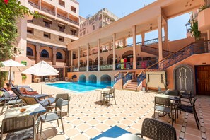 A poolside area with lounge chairs and umbrellas, a tiled floor, and a staircase leading to upper floors. - Oudaya Hotel & Spa (Marrakech)