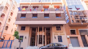 Un hotel con un cartel que dice 'HOTEL OUDAYA' y varias banderas.